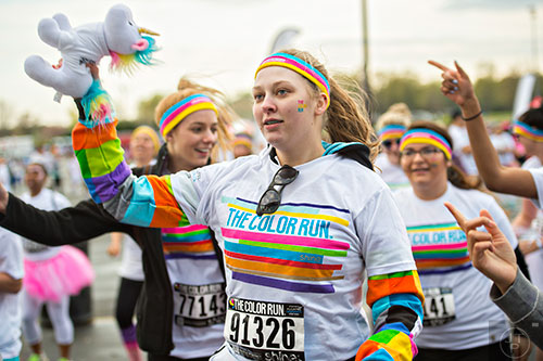 Billie Jean Jeffcoat (center) dances to a zumba warmup with her stuffed unicorn before the start of The Color Run at Atlanta Motor Speedway in Hampton on Saturday, April 4, 2015. 