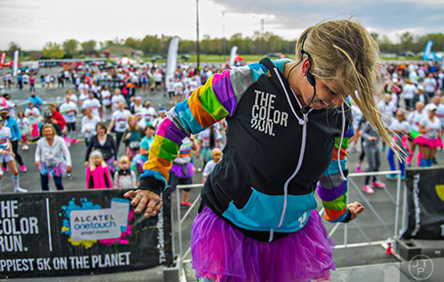 Meghan Farrell (center) leads a group of runners in a zumba warm up as they wait for the start of The Color Run at Atlanta Motor Speedway in Hampton on Saturday, April 4, 2015. 