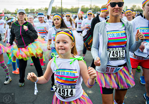 Peyton Ledoux (center) and other racers participate in a zumba warm up as they wait for the start of The Color Run at Atlanta Motor Speedway in Hampton on Saturday, April 4, 2015. 
