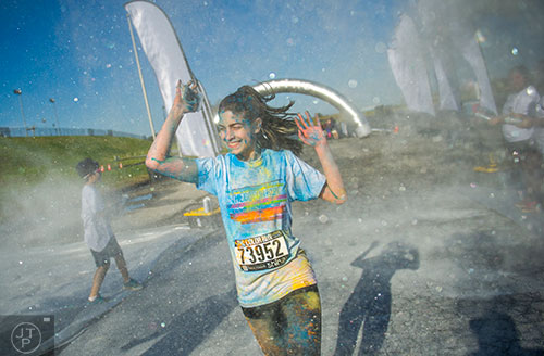 Lauren Henson runs through a cloud of silver colored dust during The Color Run at Atlanta Motor Speedway in Hampton on Saturday, April 4, 2015. 