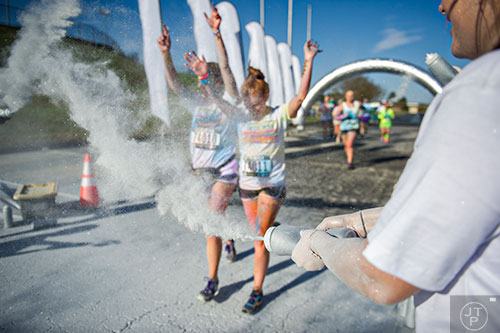 Silver colored dust is thrown at racers as they pass by during The Color Run at Atlanta Motor Speedway in Hampton on Saturday, April 4, 2015.