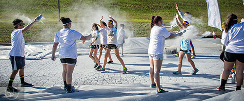Runners are covered in silver colored dust during The Color Run at Atlanta Motor Speedway in Hampton on Saturday, April 4, 2015.