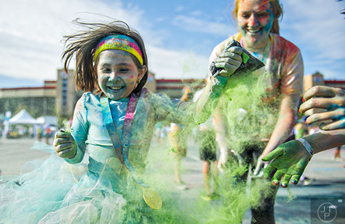 Claire Watson (left) covers herself with green colored dust  after crossing the finish line for The Color Run at Atlanta Motor Speedway in Hampton on Saturday, April 4, 2015. 