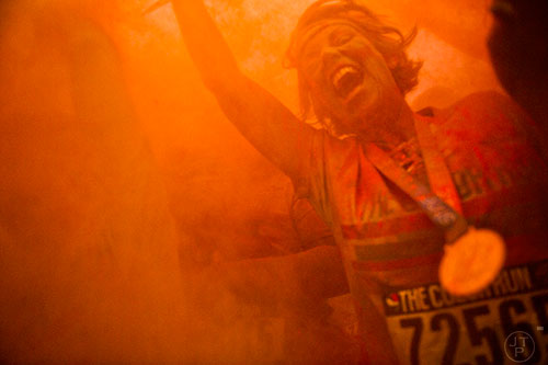 Orange colored dust covers Christine Schuvart (right) during the after party for The Color Run at Atlanta Motor Speedway in Hampton on Saturday, April 4, 2015. 