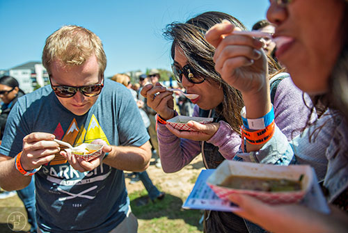 Matt Snyder (left), Christine Wang and Christine Lee sample some low country cooking during the second annual Blue Moon Beltline Boil at the Fourth Ward Skate Park along the Beltline's Eastside Trail in Atlanta on Saturday, April 4, 2015. 