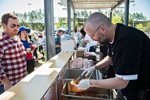 Jay Scott (right) serves up some fresh cooked food to Patrick Willbanks during the second annual Blue Moon Beltline Boil at the Fourth Ward Skate Park along the Beltline's Eastside Trail in Atlanta on Saturday, April 4, 2015. 