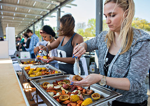 Tracy Morrow (right), Brantlee Fields and Nicole Leroux serve up fresh cooked food during the second annual Blue Moon Beltline Boil at the Fourth Ward Skate Park along the Beltline's Eastside Trail in Atlanta on Saturday, April 4, 2015. 