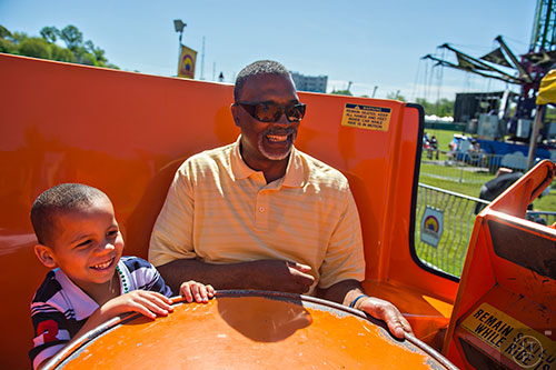 William Moore (left) and his grandfather Mark Noble ride the teacups during the 79th annual Atlanta Dogwood Festival at Piedmont Park on Saturday, April 11, 2015. 