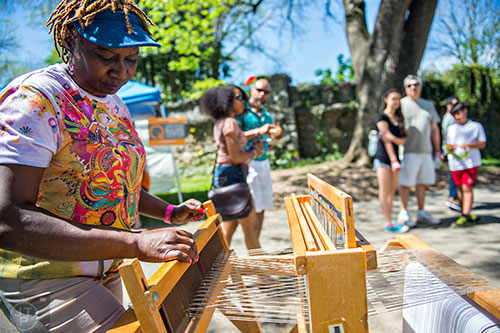Leila Wright (left) weaves using a loom during the 79th annual Atlanta Dogwood Festival at Piedmont Park on Saturday, April 11, 2015. 