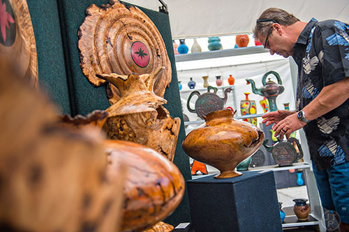 Bruce Graham checks out Shanti Yard's artwork during the 79th annual Atlanta Dogwood Festival at Piedmont Park on Saturday, April 11, 2015. 