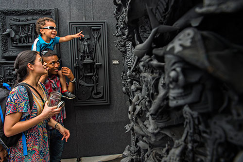 Isabel Chamberlain (left), Dorian Majied and Kazi Horne check out David Burton's artwork during the 79th annual Atlanta Dogwood Festival at Piedmont Park on Saturday, April 11, 2015. 
