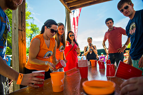 Sarah Gamache (left) plays a game of flip cup during the Hogs & Hops Festival at The Masquerade in Atlanta on Saturday, April 11, 2015. 
