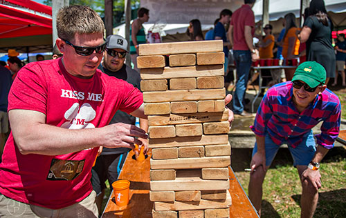 Ryan Hunsucker (left) takes his turn at a game of Jenga as Robert Walters leans in to watch during the Hogs & Hops Festival at The Masquerade in Atlanta on Saturday, April 11, 2015. 
