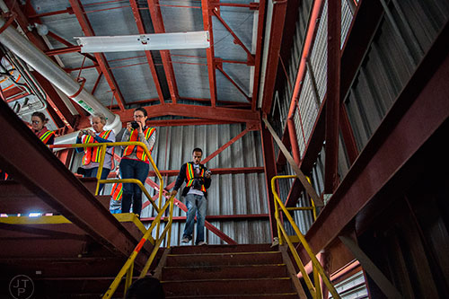 Jonathan Davis (right) walks past Sarah Reiff and Margie Bowen as they take photographs inside one of the few buildings that remain standing during a #weloveatl photowalk of the General Motors assembly plant in Doraville on Sunday, April 12, 2015. 