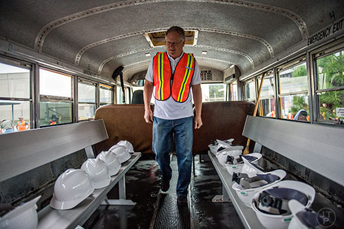 Dale Bowen walks past rows of hardhats as he and other photographers board a bus to take them into the General Motors assembly plant in Doraville during a #weloveatl photowalk on Sunday, April 12, 2015. 
