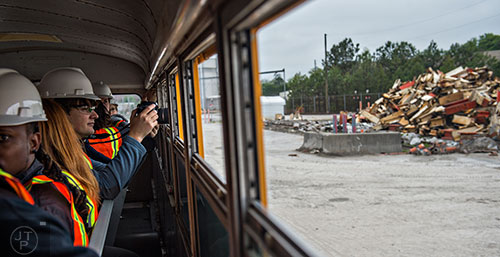 Andrey Morochko takes a photograph out of the window of a bus during a #weloveatl photowalk of the General Motors assembly plant in Doraville on Sunday, April 12, 2015. 