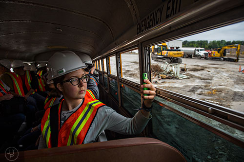 Haley Parker takes a photograph out of the window of a bus during a #weloveatl photowalk of the General Motors assembly plant in Doraville on Sunday, April 12, 2015. 