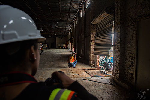 Stan Mayhew (center) and Porsche Rittenhouse take photographs in one of the buildings inside the General Motors assembly plant in Doraville during a #weloveatl photowalk on Sunday, April 12, 2015. 