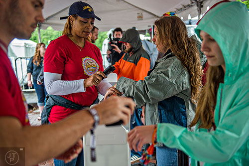 Phyllis Tallant (left) scans Sarah Wise's bracelet as she enters the SweetWater 420 Fest at Centennial Olympic Park in Atlanta on Friday, April 17, 2015. 