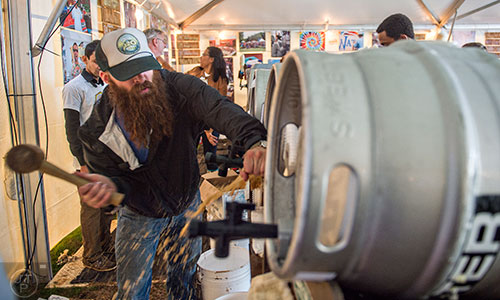 Cameron Alme (left) taps a keg during the SweetWater 420 Fest at Centennial Olympic Park in Atlanta on Friday, April 17, 2015. 