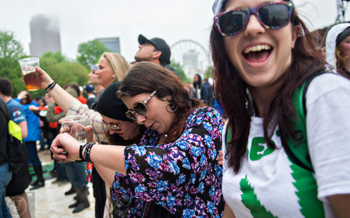 Sam Gatti (center) dances with her sister Leah as Aer performs on stage during the SweetWater 420 Fest at Centennial Olympic Park in Atlanta on Friday, April 17, 2015. 