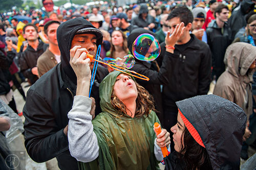 Stephen White (left) and his wife Lexy blow bubbles as Aer performs on stage during the SweetWater 420 Fest at Centennial Olympic Park in Atlanta on Friday, April 17, 2015. 