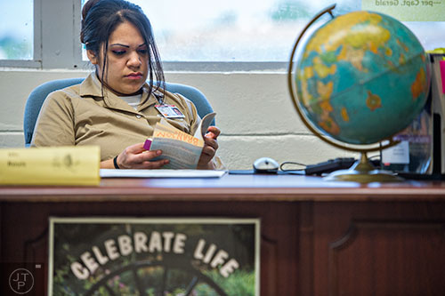 Camelia Ponce flips through a novel as she sits in the charter school program at the Lee Arrendale Correctional Facility in Alto on Friday, April 10, 2015. 