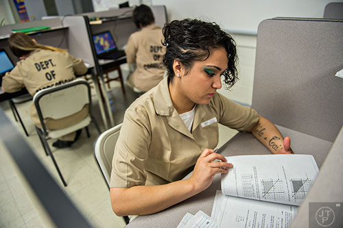 Krystal Almaraz (right) works on linear programming as she works to get her high school diploma through the charter school program at the Lee Arrendale Correctional Facility in Alto on Friday, April 10, 2015. 