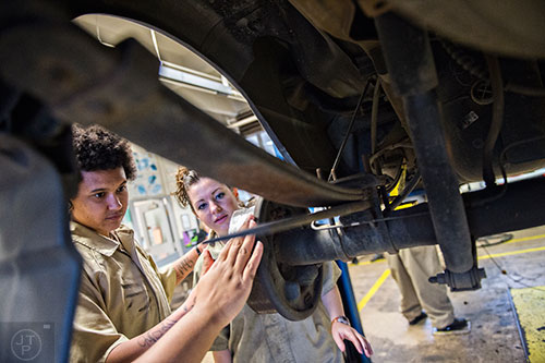 Kiara Miller (left) and Amanda Chaney look at the brakes on a pickup truck during automotive class at the Lee Arrendale Correctional Facility in Alto on Friday, April 10, 2015. 