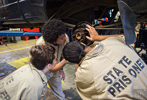 Amanda Chaney (left), Kiara Miller and another inmate look at the brakes on a pickup truck during automotive class at the Lee Arrendale Correctional Facility in Alto on Friday, April 10, 2015. 