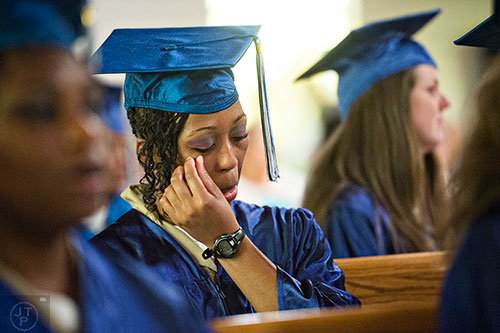 Shenneake Simms (center) wipes a tear from her eye during the graduation ceremony for theological studies at the Lee Arrendale Correctional Facility in Alto on Friday, April 10, 2015. 