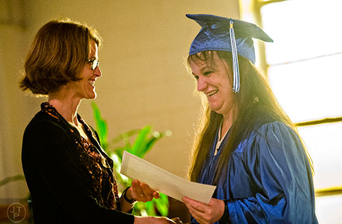 Patricia Stapler (right) is handed her certificate by Cathy Zappa during the graduation ceremony for theological studies at the Lee Arrendale Correctional Facility in Alto on Friday, April 10, 2015. 