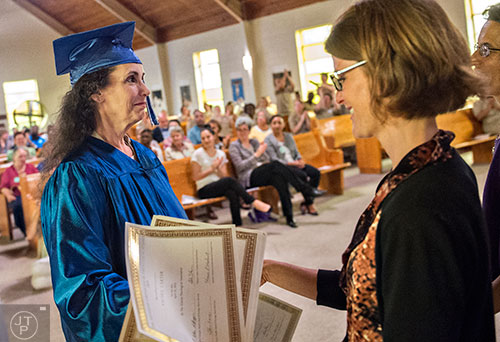 Sonya Bamberg (left) is handed her certificate by Cathy Zappa during the graduation ceremony for theological studies at the Lee Arrendale Correctional Facility in Alto on Friday, April 10, 2015.