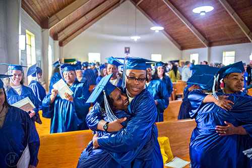 Veronica Fuller (center) hugs Ameshia Ervin (left) after graduating from the theological studies certficate program at the Lee Arrendale Correctional Facility in Alto on Friday, April 10, 2015. 