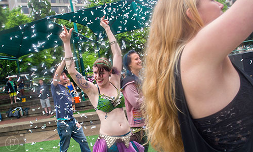 Confetti falls on Lydia Bishop (center) as she dances while Shine Live performs on stage during the last day of the SweetWater 420 Fest at Centennial Olympic Park in Atlanta on Sunday, April 19, 2015.