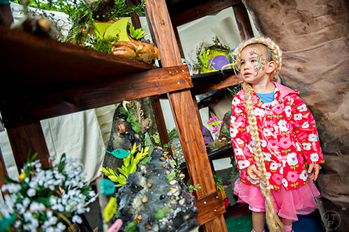 Ella Schuckenbrock looks at the fairy houses in the Stuff From Stuff booth during the Inman Park Festival in Atlanta on Saturday, April 25, 2015. 