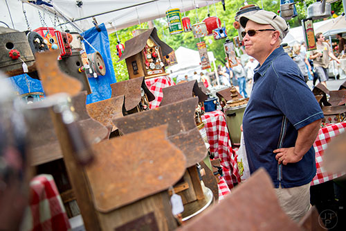 Michael Miller looks at the Aljie's Vintage Birdhouses booth during the Inman Park Festival in Atlanta on Saturday, April 25, 2015. 