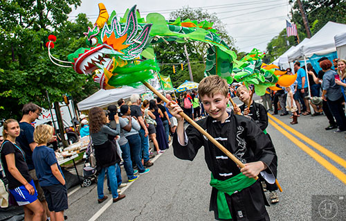 Gabe Simpson (right) works the head of a dragon as he marches in the parade during the Inman Park Festival in Atlanta on Saturday, April 25, 2015. 