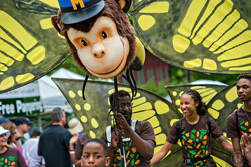 Raymond Carr (center) and Alexis Burton participate in the parade during the Inman Park Festival in Atlanta on Saturday, April 25, 2015. 