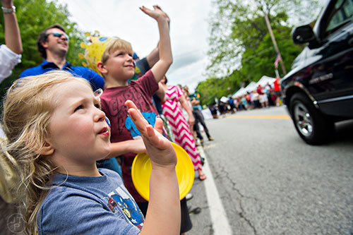 Alaina Clements (left) and her brother Atticus wave as the parade passes by during the Inman Park Festival in Atlanta on Saturday, April 25, 2015. 