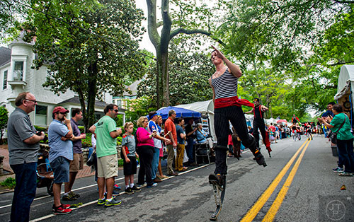Logan Vaught runs down the parade route on spring stilts during the Inman Park Festival in Atlanta on Saturday, April 25, 2015. 