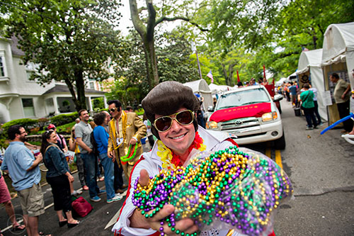Dressed as Elvis, Dave Hartman carries beads down the parade route during the Inman Park Festival in Atlanta on Saturday, April 25, 2015. 