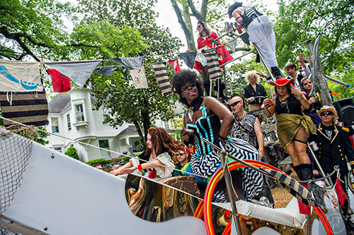 Lola Leesoleil (center) rides a float down the parade route during the Inman Park Festival in Atlanta on Saturday, April 25, 2015. 