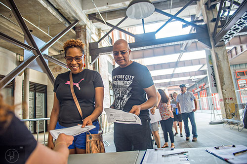 Leslie Guy (left) and Kirk Williams show their tickets for Nick Cave's Up Right: Atlanta performance at Ponce City Market on Sunday, April 26, 2015. 