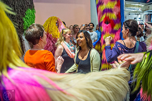 Kiran Fantania (center) and other onlookers are circled by dancers as they perform during Nick Cave's Up Right: Atlanta performance at Ponce City Market on Sunday, April 26, 2015. 