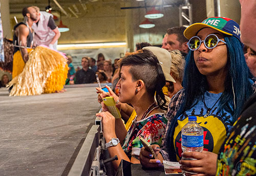 Kashmir Reed (right) and Jennifer Irby watch as dancers are dressed in their costumes during Nick Cave's Up Right: Atlanta performance at Ponce City Market on Sunday, April 26, 2015. 