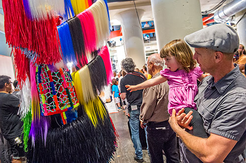 Brian Thorpe (right) holds his daughter Delia as she reaches for one of the performers during Nick Cave's Up Right: Atlanta performance at Ponce City Market on Sunday, April 26, 2015. 