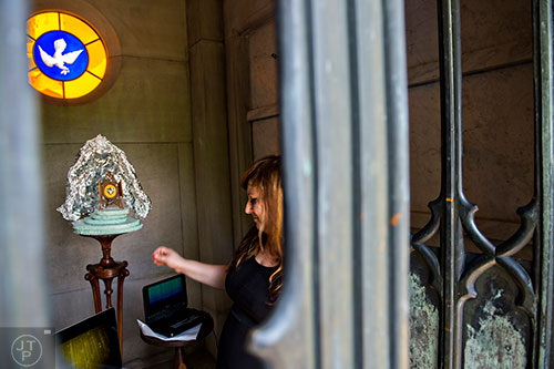 Paige Adair sets up her installation inside one of the crypts at Oakland Cemetery in Atlanta on Sunday, April 26, 2015. 