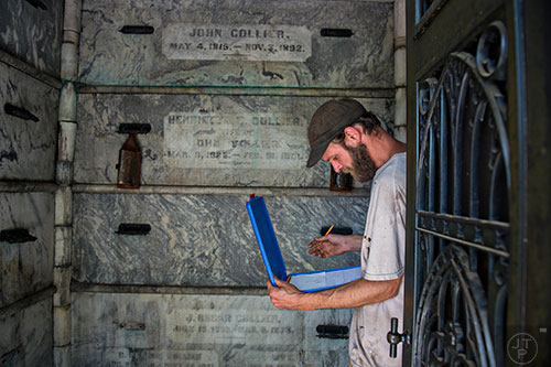 S Bedford takes notes as he measures one of the crypts at Oakland Cemetery in Atlanta on Sunday, April 26, 2015. 
