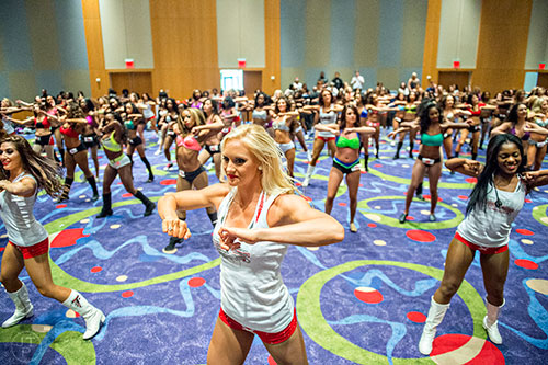 Current Falcons cheerleader Kat Majester (center) leads hopefuls through a dance routine before first cut tryouts begin for the Atlanta Falcons Cheerleaders at the Georgia International Convention Center in Atlanta on Sunday, May 3, 2015. 